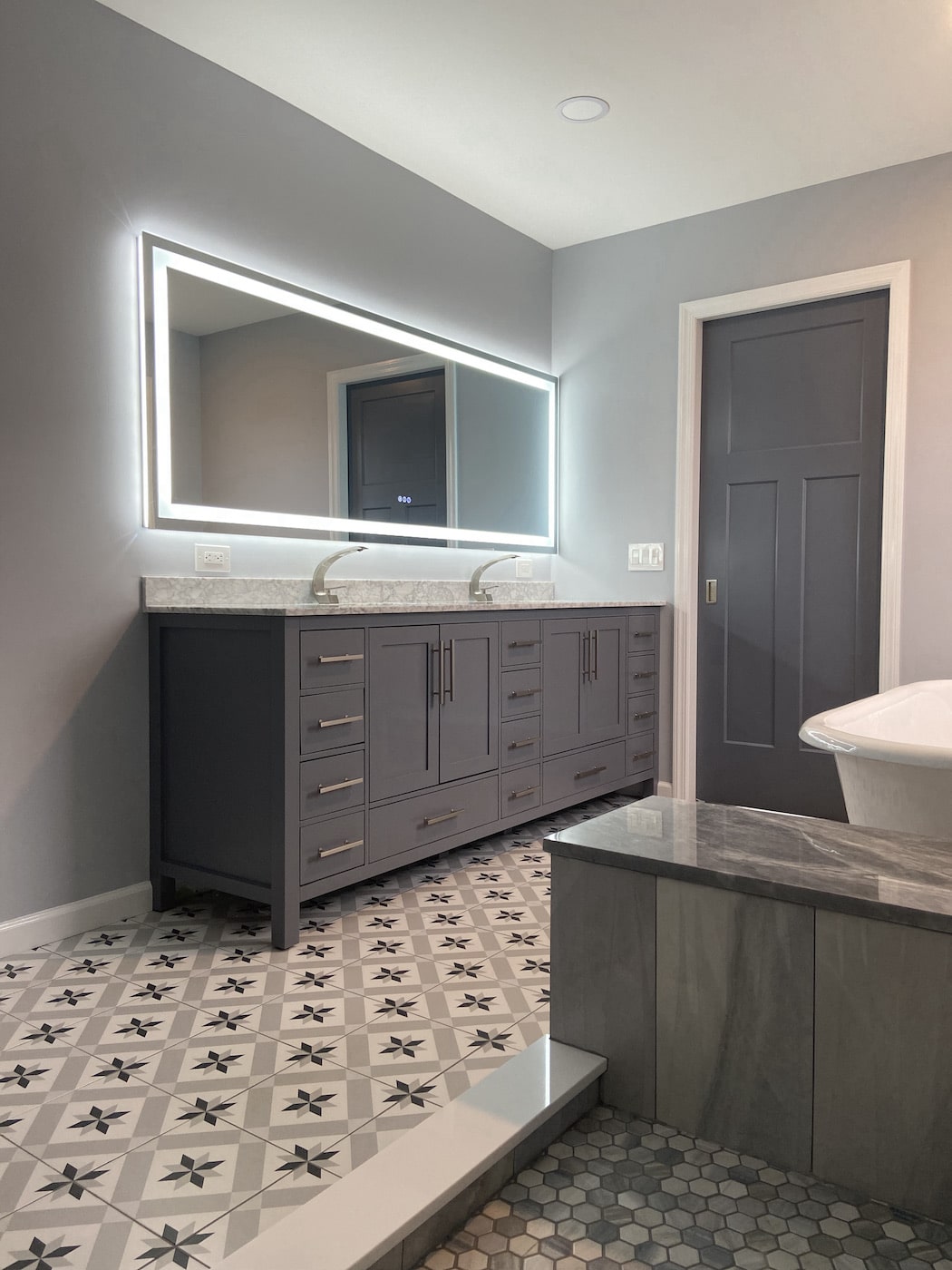 A grey vanity with a light up mirror in New City, NY. Contractors - Loughlin & Son Construction.