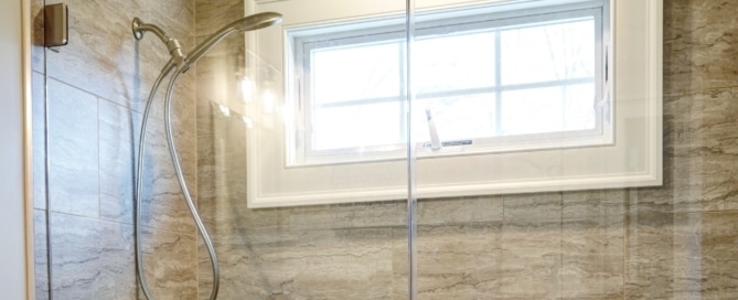 A renovated bathroom shower in New City, New York with modern glass doors. Contractors - Loughlin & Son Construction.