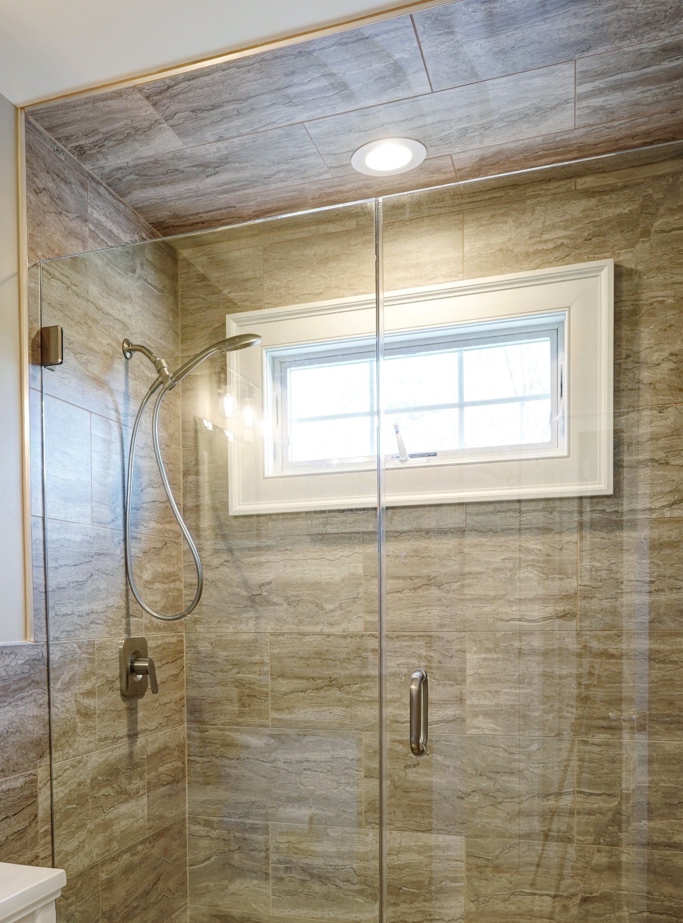 A renovated bathroom shower in New City, New York with modern glass doors. Contractors - Loughlin & Son Construction.